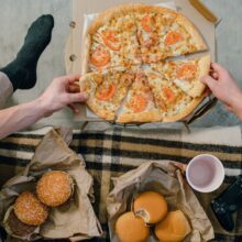 Cozy setup with pizza, burgers, and gaming controller, perfect for casual indoor hangouts.
